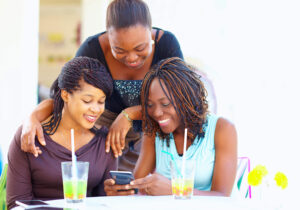 LinkedIn in 2026: 3 ethically diverse young people gathered around a computer screen
