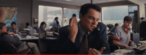 a white make wearing suit and tie speaking firmly over the telephone