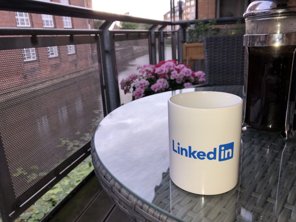 On LinkedIn Posts or Blogs: A white mug resting on a coffee table. The mug has the "LinkedIn" logo on it.