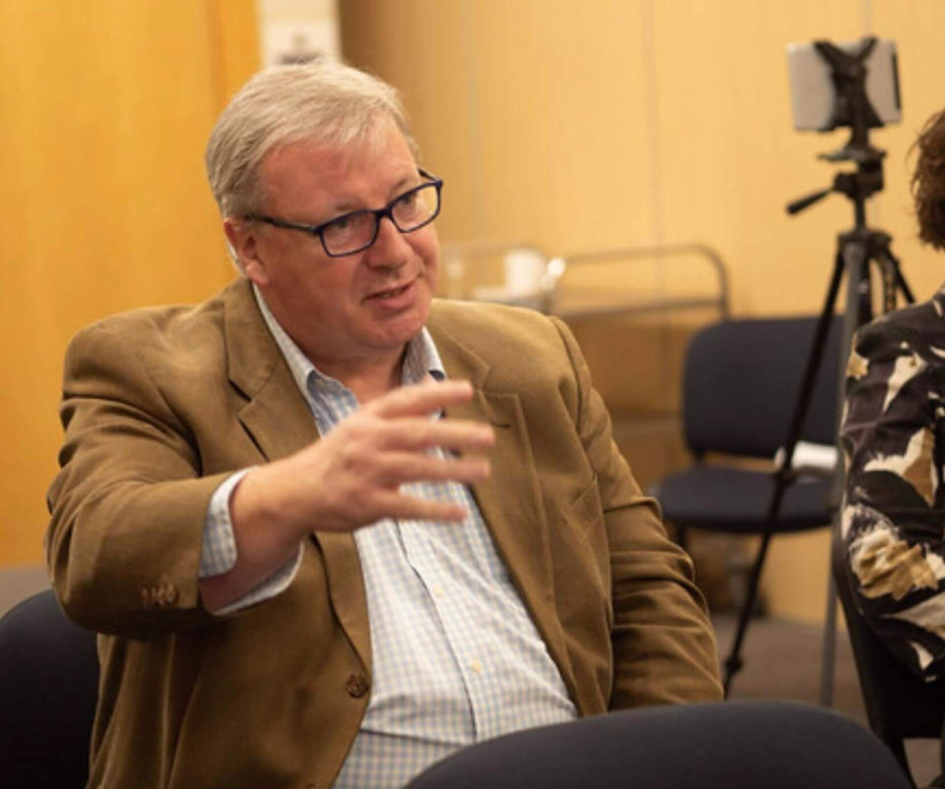 Middle aged white man wearing blue glasses
